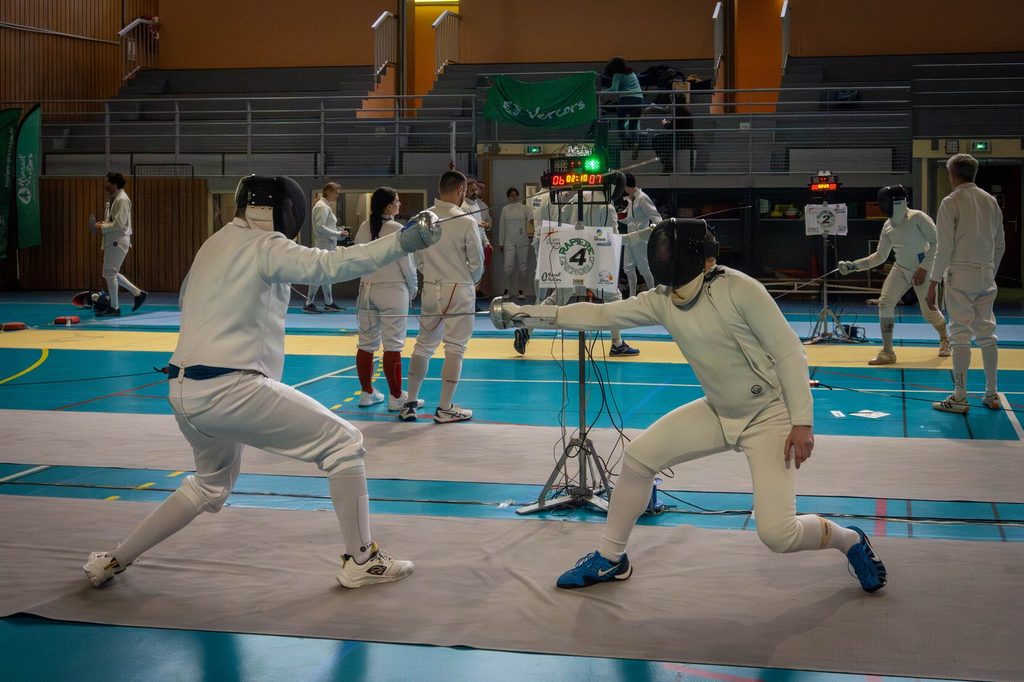 Deux épéistes en combat sur la piste pendant la Vercors Cup 2026, en plein milieu d'une touche.