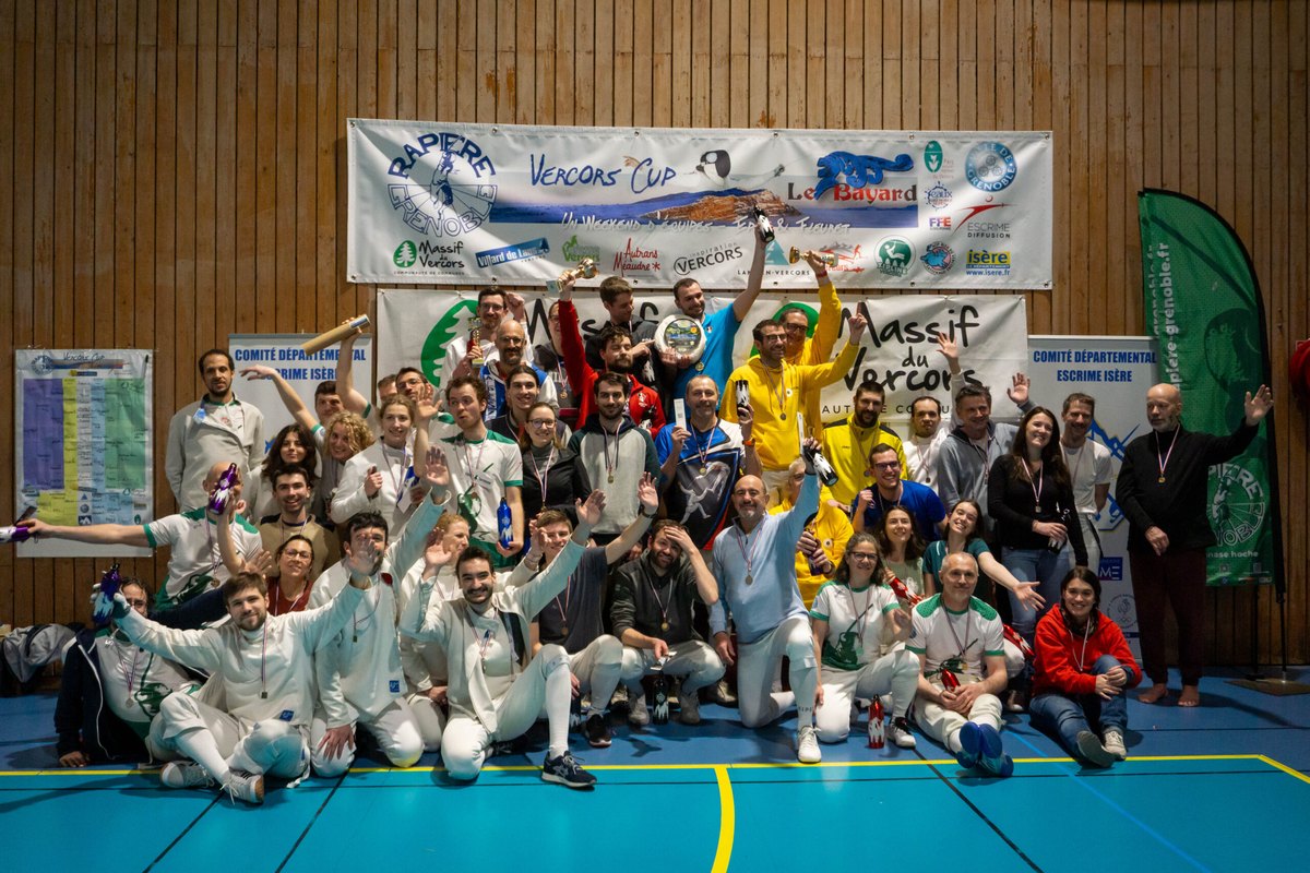 Toutes les équipes réunies devant le podium à la fin de la Vercors Cup, coupes et médailles levées, sous la bannière de la compétition